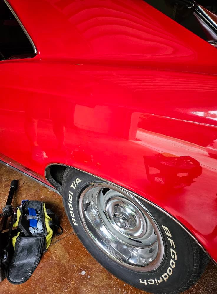 Glossy red classic car panel restored with paintless dent repair